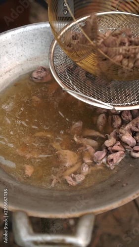 Cooking Thai stir-fried chicken entrails with holy basil (Phad Ka Prao Khreuang Nai Gai). Blanching chicken entrails, sautéing chili and garlic, tossing with entrails, seasonings, and holy basil.