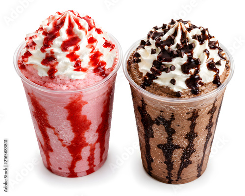 Cold strawberry and chocolate milkshakes topped with whipped cream in clear plastic cups side together