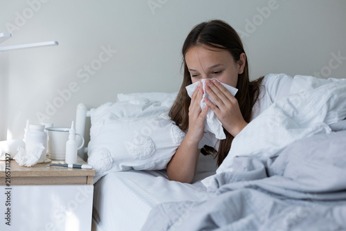 Foto Sick girl with runny cold symptoms resting at home, representing illness, flu an