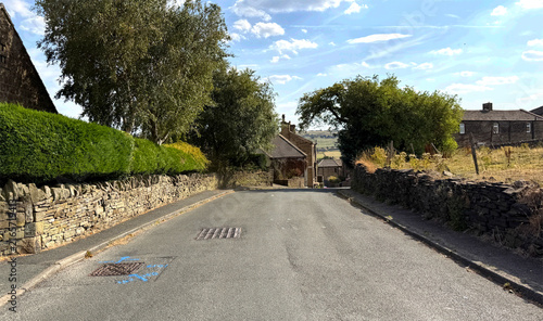 Foto A quiet country road lined with dry stone walls leads towards a small village