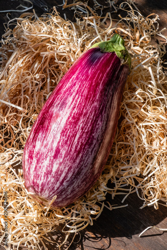 Organic vegetable, aubergine on a wooden table outdoors in summer