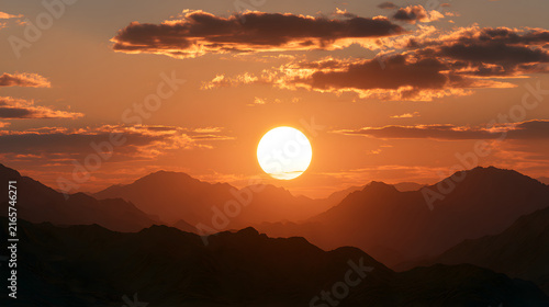 Stunning sunset over majestic mountains, casting a warm glow with vibrant orange hues.