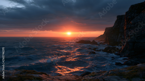 Stunning sunset over rugged cliffs, reflecting vibrant colors on the ocean waves.