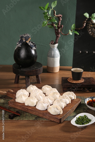 Quadro su tela Traditional Handmade Dumplings on Wooden Board with Asian Tea Service and Kitche
