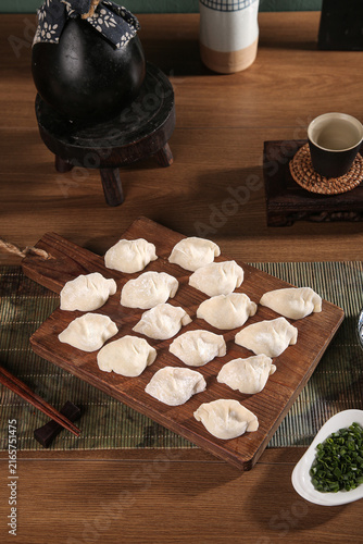 Foto Traditional handmade seafood dumplings on wooden board with Asian kitchen utensi