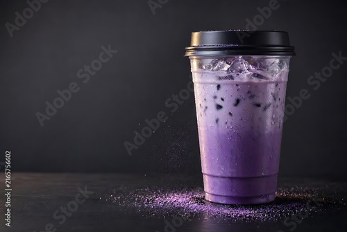 Refreshing Iced Purple Taro Milk Tea in Transparent Plastic Cup with Black Lid on Dark Background with Powder Spillage