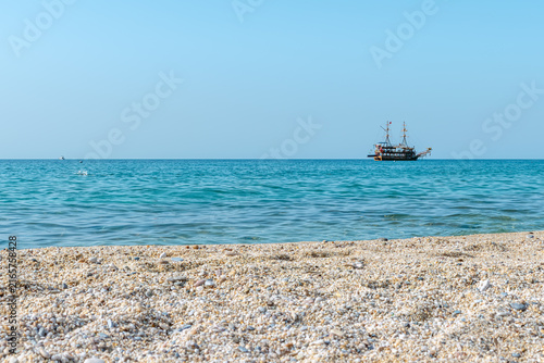 Canvas Print Pirate-style tourist ship sails on the turquoise Mediterranean Sea off Cleopatra Beach in Alanya, Turkey