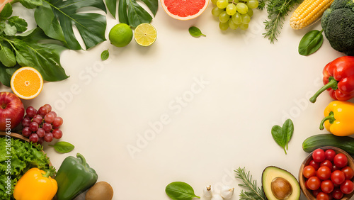 Fresh organic fruits and vegetables arranged as a frame on a light background.