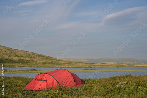 Foto Red Expedition Tunnel Tent Pitch on Alpine Lake Shore at Twilight