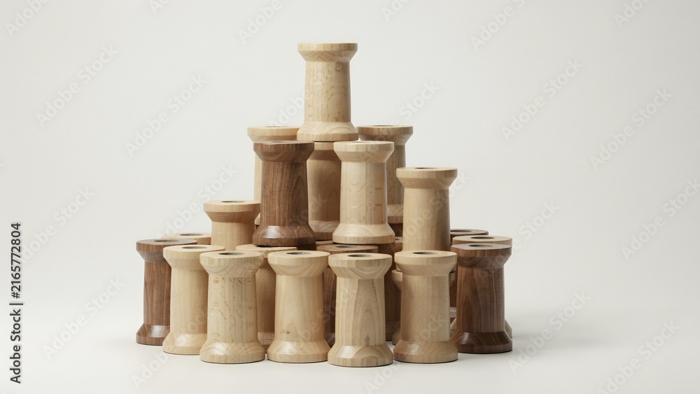 Naklejka premium Wooden Spools Arranged in a Creative Pile on a White Background