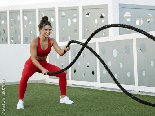 young woman exercising with ropes.