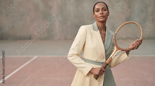Elegant Black Woman Holding Vintage Tennis Racket in High Fashion Portrait