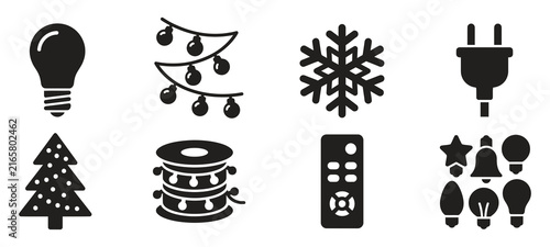 Set of black silhouette icons representing christmas holiday decorations light bulbs snowflakes electrical plugs and festive tree ornaments on white background