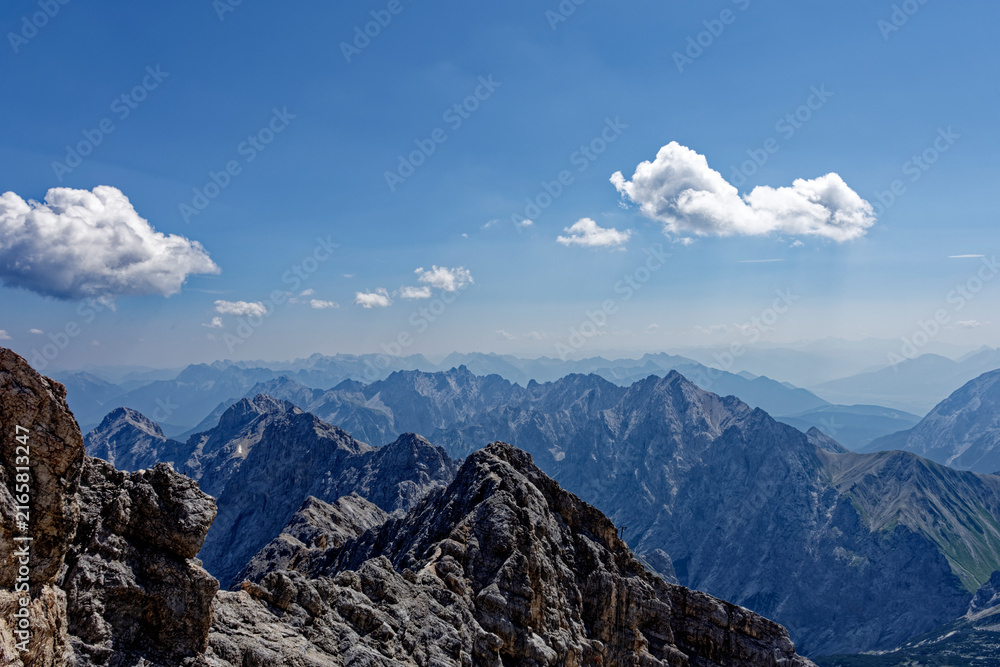 Obraz premium Layered Alpine Mountain Ranges and Paraglider Viewed from Zugspitze Summit