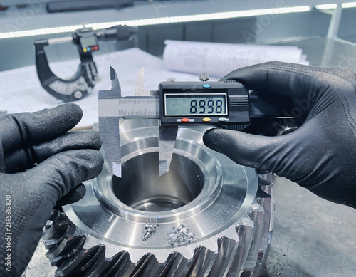 engineer measuring part  with caliper