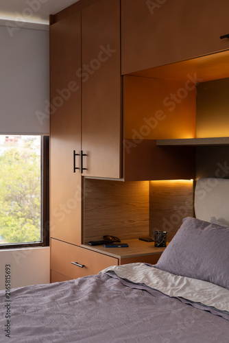 Fotografie Elegant bedroom interior with cozy bed and warm indirect lighting for modern hom