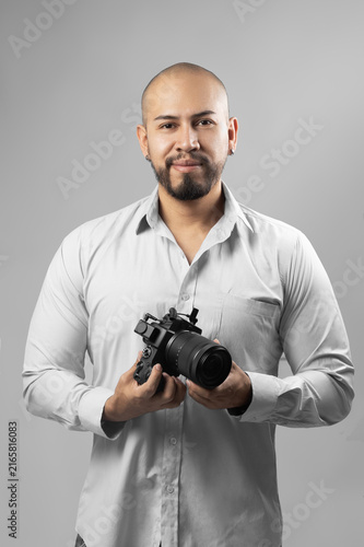 Handsome young man holding a professional camera, photography studio, lifestyle and work place