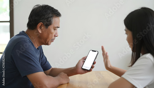 Older Adult Pausing Suspicious Mobile Payment with Family Member