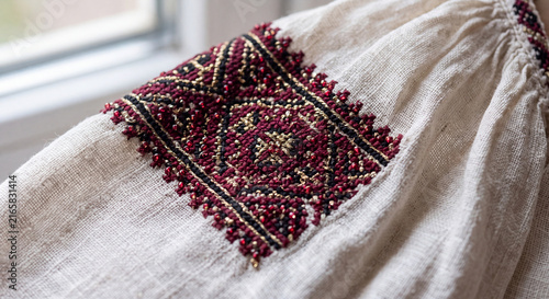 A macro, hyper-focused shot of the complex hand-embroidery on the sleeve of an authentic, vintage Romanian 