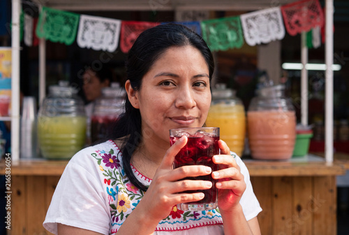 Mexican Woman Drinking Cold Hibiscus Tea at Street Stall