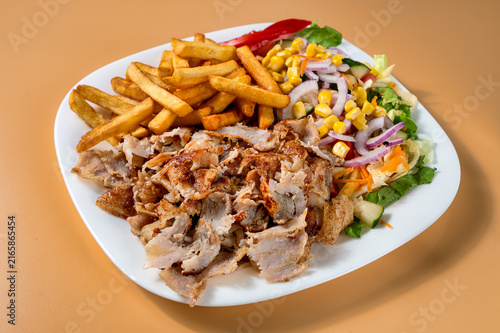 Canvastavla Kebab plate with shaved roasted meat, French fries and fresh mixed salad with corn, onion, tomato, carrot and lettuce