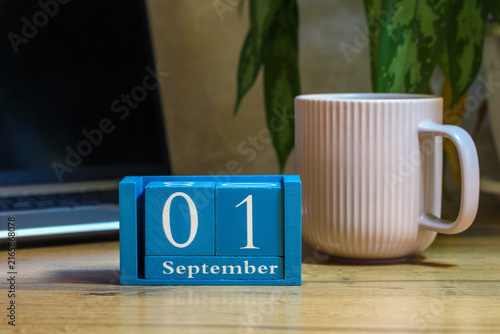 September 1, Knowledge Day. blue block calendar, laptop, and mug on the desk. back to school.