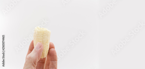 Foto Parte di frutto di banana matura tenuto tra le dita di una mano primo piano su s
