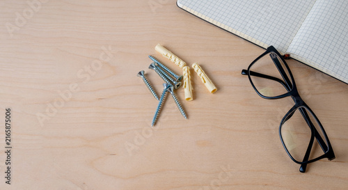 Konstfotografi Notebook, glasses, ruler, screws, and dowels on wood