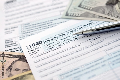Cuadro en lienzo 1040 Individual Income tax return form and pen with dollars money bills on accou