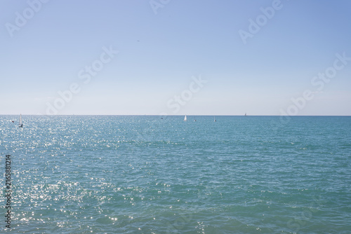 Sparkling Turquoise Ocean with Sailboats on Sunny Day