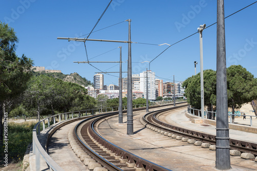 Curved Railroad Tracks with Overhead Electric Lines in Urban Setting