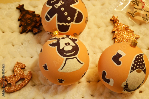 Christmas balls for decorating a Christmas tree or room design. beautiful balls on the background of a Christmas tree with a glowing garland. deer, gnome and gingerbread man smiling in the new year