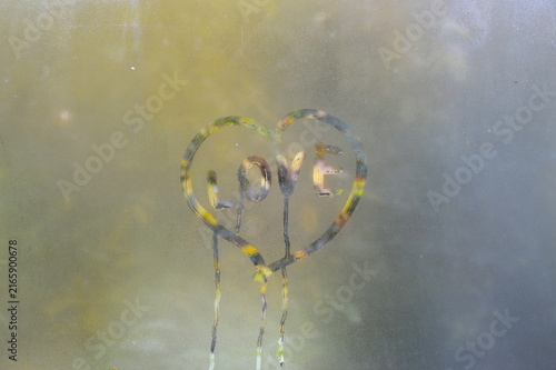Autumn rain and a heart painted on misted glass. a symbol of love, devotion, friendship and sympathy. confession of feelings expressed in the picture on the window