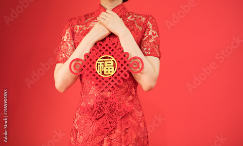 Fotografía Woman in Red Qipao Holding Chinese Fu Decoration for Chinese New Year