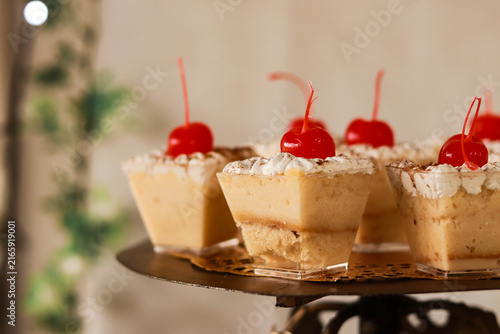 Foto Mini Cream Desserts Topped with Red Cherries