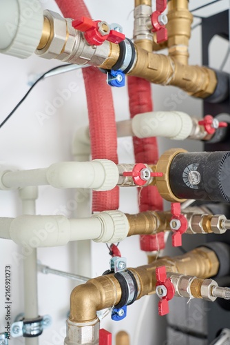 Water pipes, brass fittings, valves and circulation equipment in a home utility room