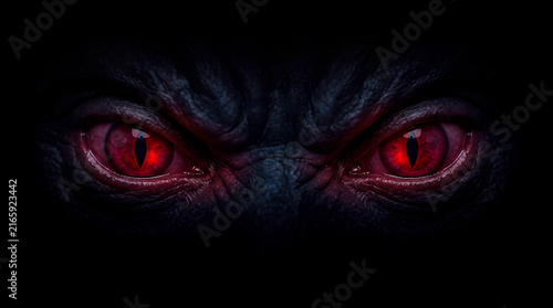 Glowing red demonic eyes staring from the dark