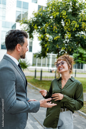 Business people talk outside a modern building during the day