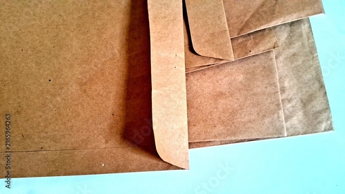 Bild auf Leinwand Brown paper envelopes stacked neatly on a clean white desk surface