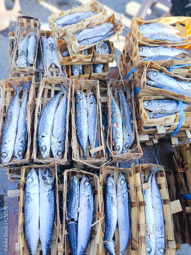 Cuadro en lienzo Fresh mackerel fish in woven bamboo baskets at an outdoor seafood market, vibran