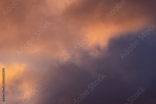 Foto Dramatic low-angle view of intense sunset-colored clouds blending from bright orange to dark heavy purple storm masses, creating a perfect mood-driven atmospheric background for scenic nature design