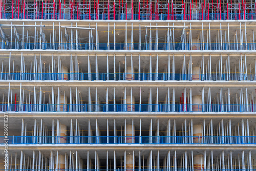 Foto The image shows a multi storey high rise concrete structure under active construction, featuring concrete columns, floor slabs, temporal vertical Shoring and safety railings