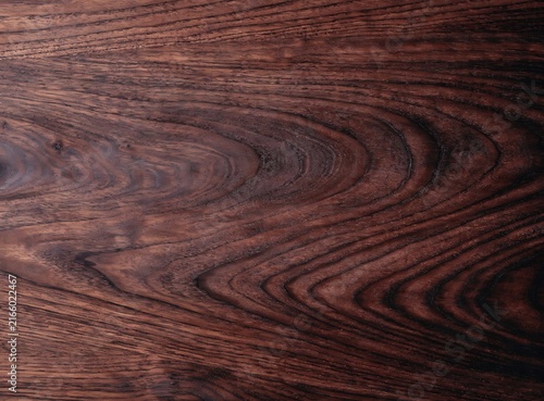 Dark red wood grain texture with natural patterns and flowing lines for interior design backgrounds and surfaces