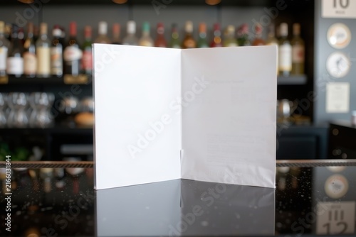 White menu rests on polished bar surface