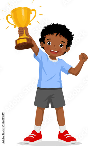 Little African boy holding gold cup trophy feeling excited celebrating for victory and achievement
