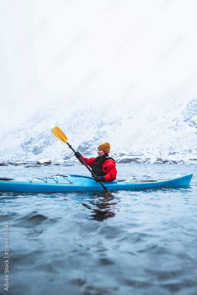 Fototapeta premium Woman paddling a kayak in Lofoten, Norway
