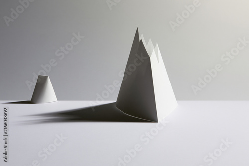 Folded paper casting a mountain shaped shadow surreal concept