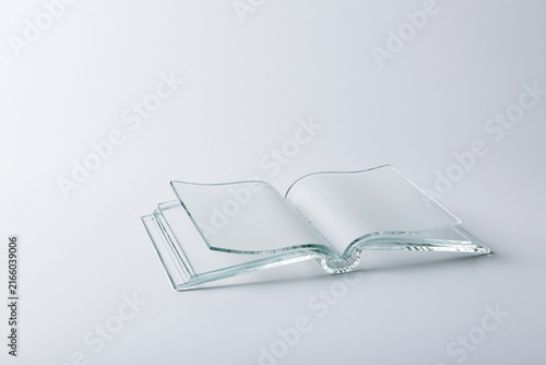 Open book made entirely of clear glass surreal knowledge concept