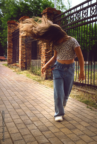 Foto Happy young girl enjoys walking, dancing and jumping freely in the summer sun