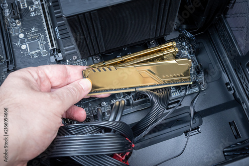 Foto Golden DDR module held in technician's hand symbolizing rising cost of RAM due to AI market demand